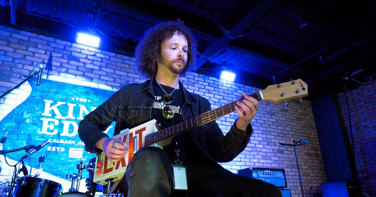 David Blitt, National Music Centre school and public programs educator, plays Kevin McAuley’s exit sign guitar on the stage at the King Eddy.